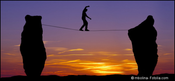 Silhouette of a man walking on the tightrope